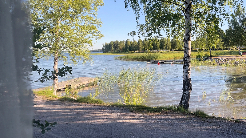 Kuva matkailuauton ikkunasta järvelle päin Parikkalan matkaparkissa. Järvi on aivan vieressä.