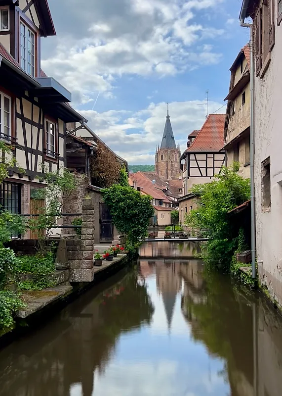 Wissembourg kaupungin kanaali, jossa kirkko näkyy taustalla.