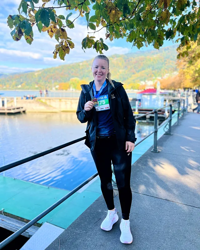 Marathonin jälkeen Bodensee järven rannalla ruskamaisemissa mitalli kaulassa.
