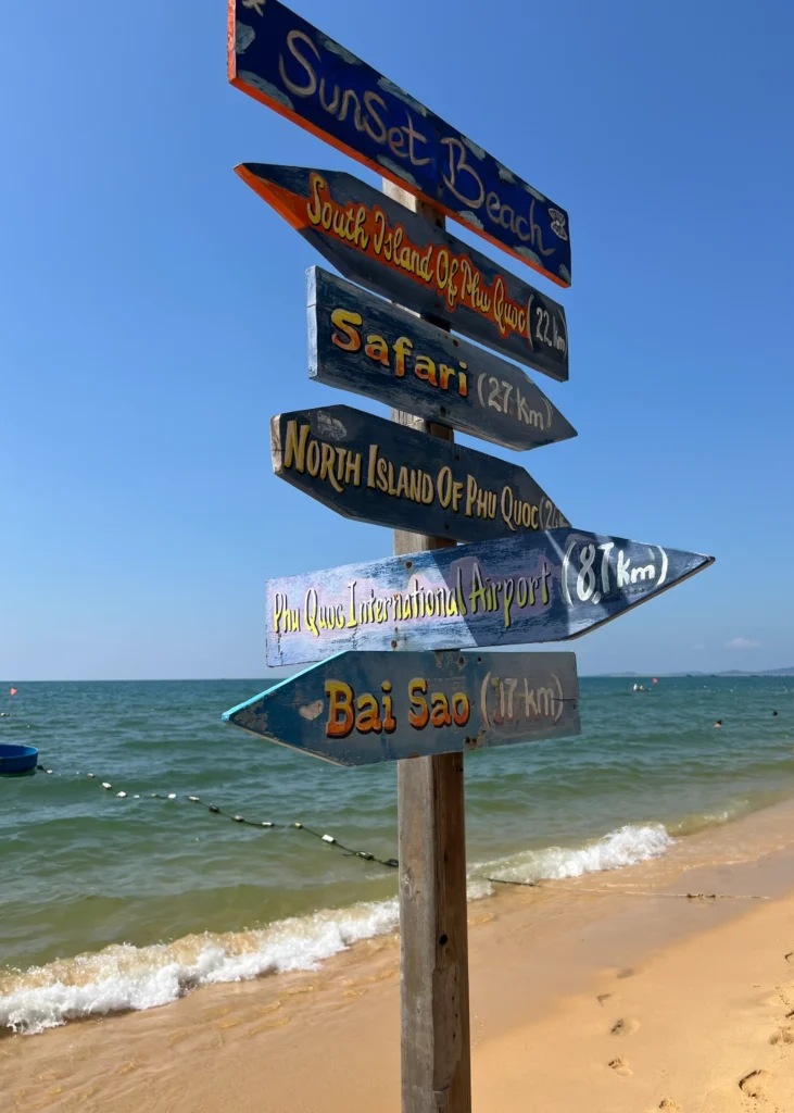 Puusta tehty värikkäät suuntaa osoittavat kyltit Phu Quocin rannalla.