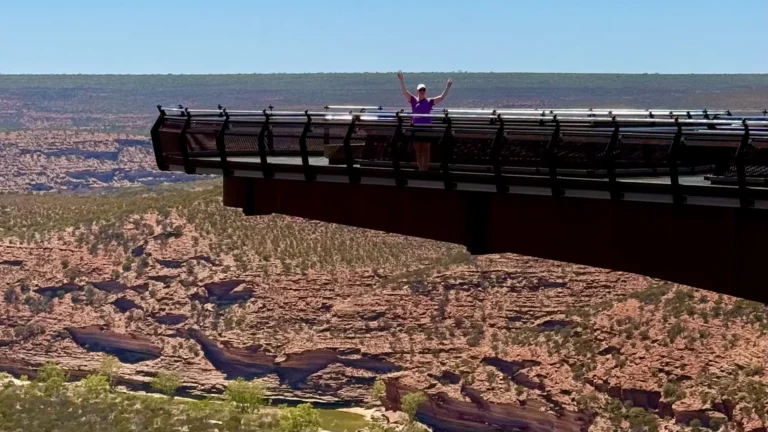 Kalbarri Skywalkilla seisomassa kädet pystyssä. Taustalla rotkomaisemaa.