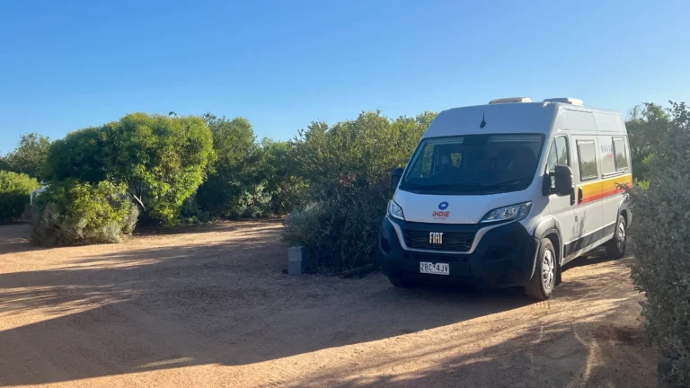 Retkeilyauto Coro Parkin lerintäalueen parkissa puska-aita ympärillä.