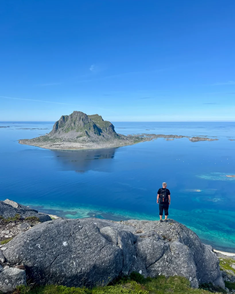 Vegatrappan huipulla täysin tyyni meri ja merestä nouseva vuori taustalla.
