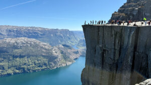 Preikestolen pulpit rockilla paljon ihmisiä aurinkoisella säällä.